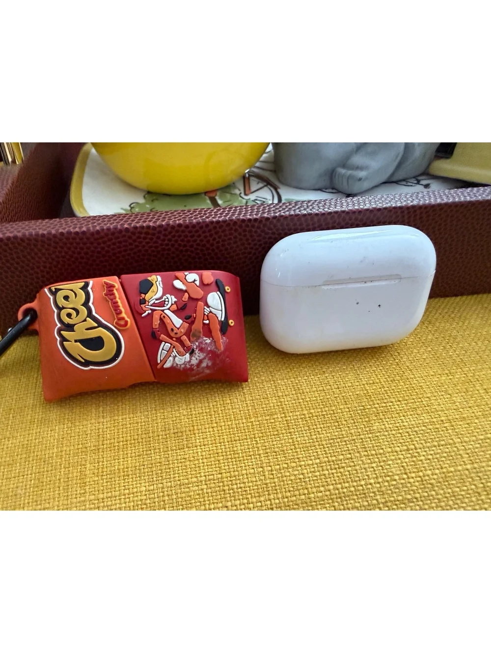 AirPods charger and half of a Cheetos case